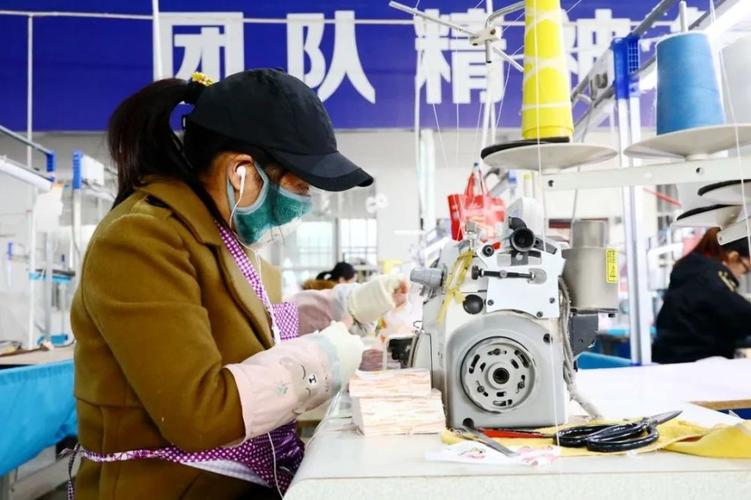 1月13日,在融安县汇鑫针织服装厂生产车间内,一名女工在缝制童装.